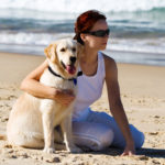 Chica con su perro en la playa